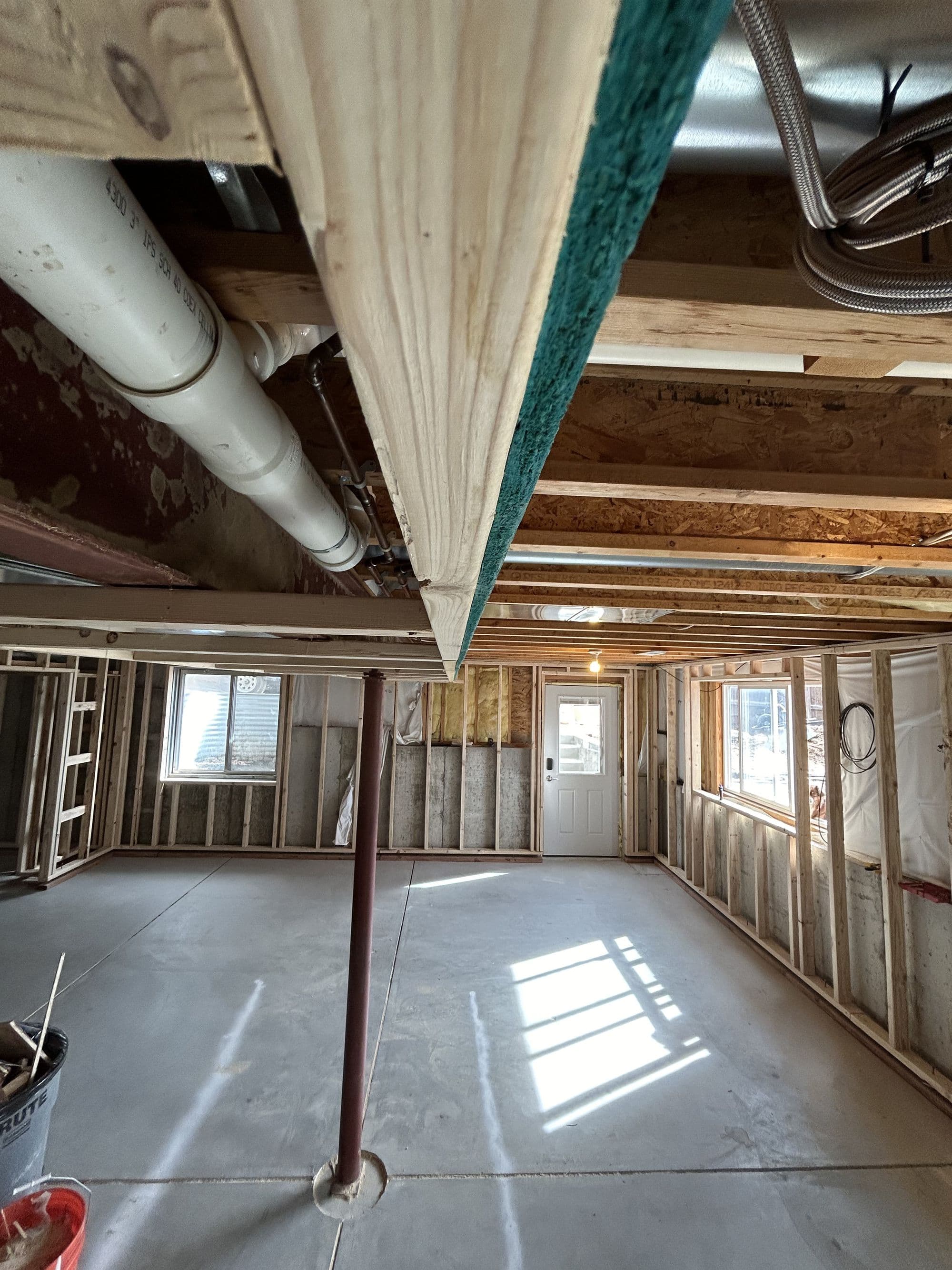 Basement framing nearing completion, window-lit room