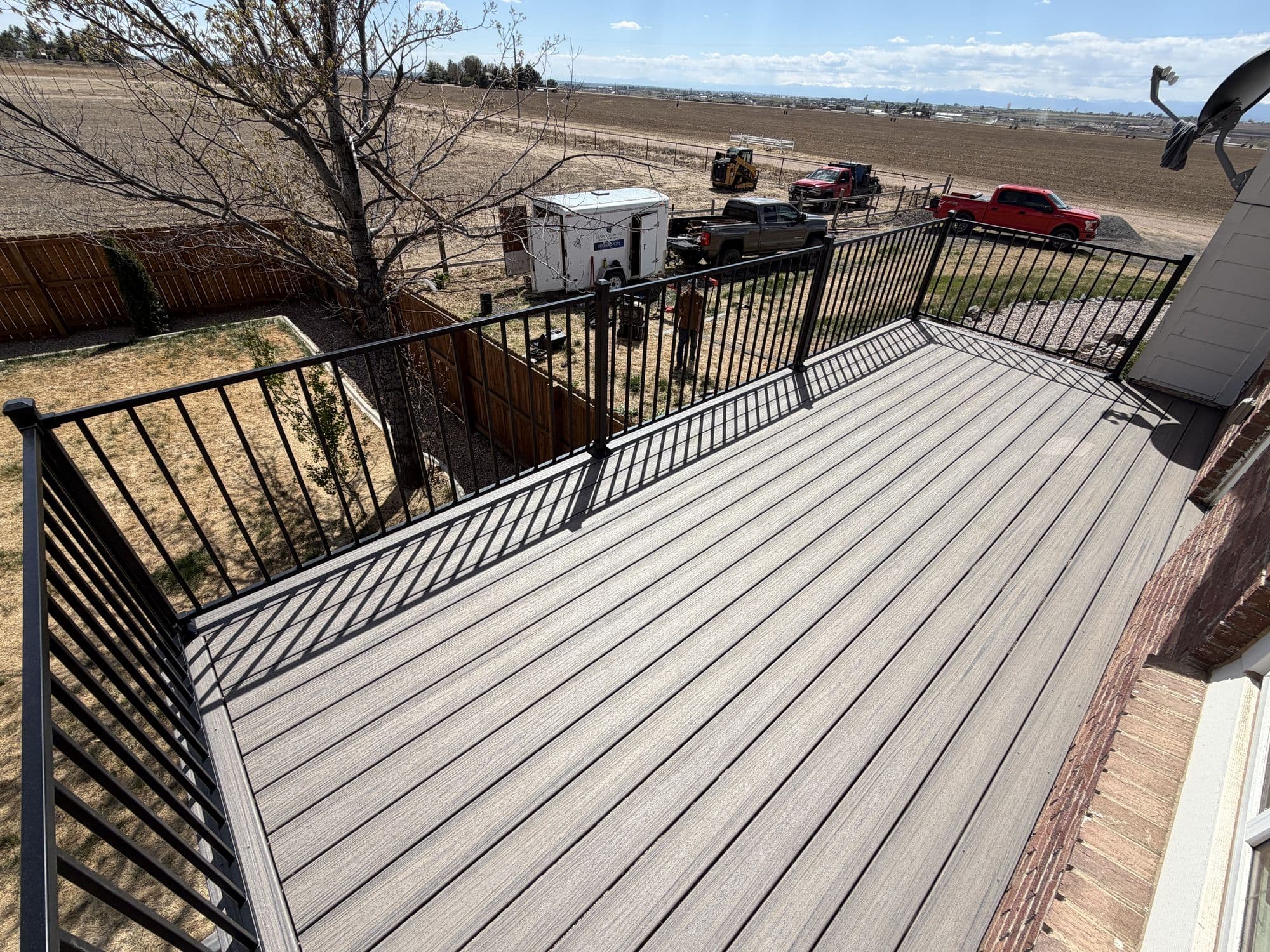 Finished composite deck, close view with brick home