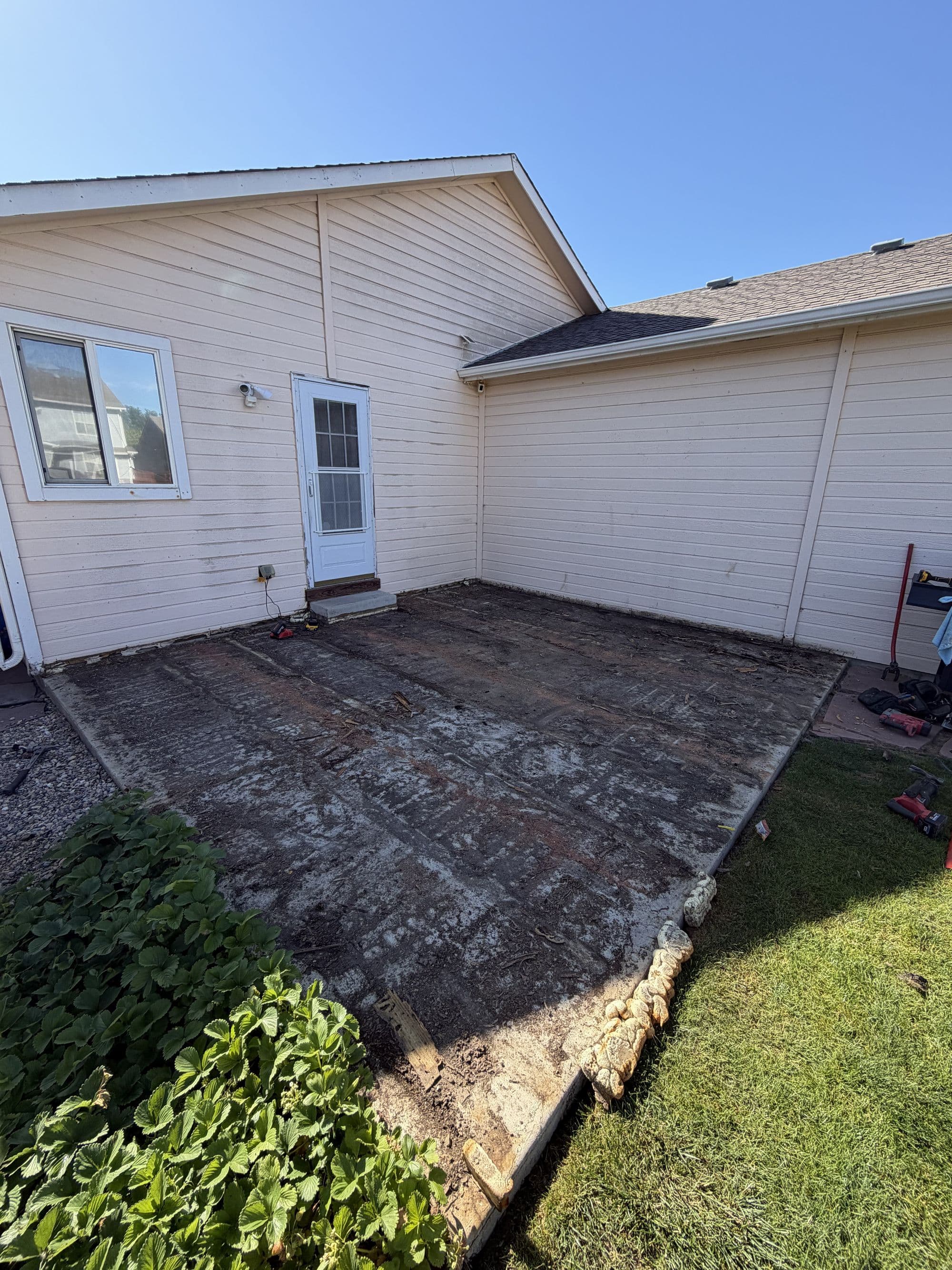 Patio cleared down to bare concrete during a deck replacement